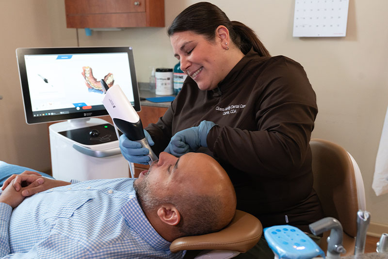 Team member taking 3d scan of patients teeth