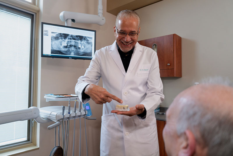 Doctor holding a model of dental implants