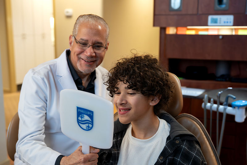 Patient and doctor smiling into mirror